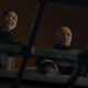 Fennic Shand smirks and Boba Fett looks dead-eyed at something under a metal grate.